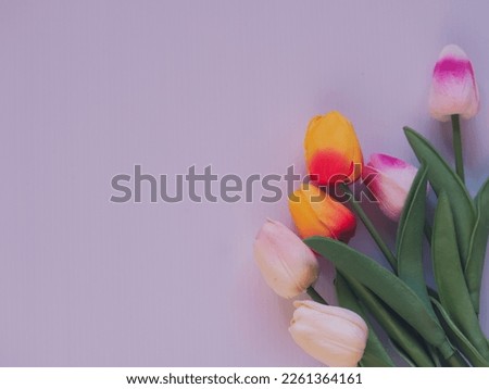 Fake tulips on white plastic sheet background for copy space.