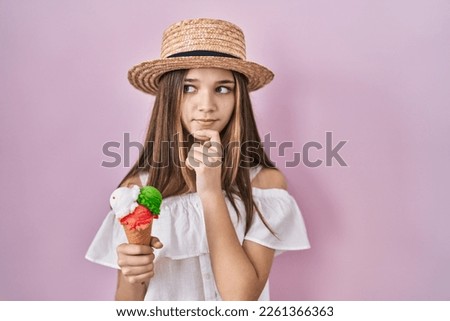Teenager girl holding ice cream thinking worried about a question, concerned and nervous with hand on chin 