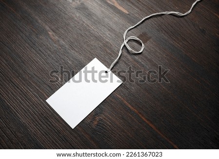 Blank white paper tag on wooden background. Copy space for text.