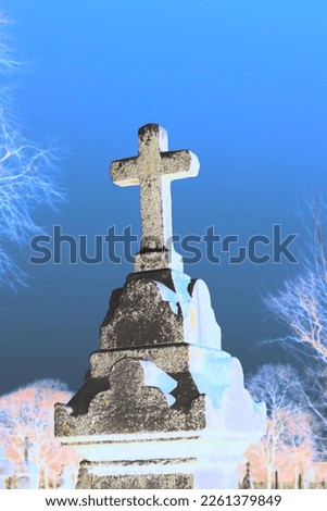 Old stone cross standing in the cemetery as a memorial of one’s Christian faith.