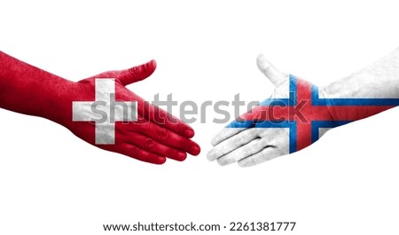 Handshake between Switzerland and Faroe Islands flags painted on hands, isolated transparent image.