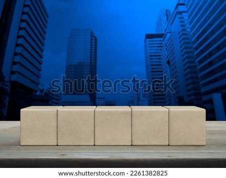 Five wood block cubes on wooden table over modern office city tower and skyscraper
