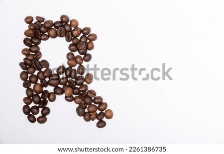 R is a capital letter of the English alphabet made up of natural roasted coffee beans that lie on a white background.