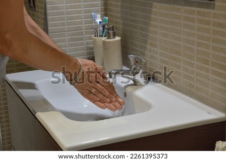 hands under the faucet. Detail of the hygiene concept. Washing hands with soap under the faucet with water