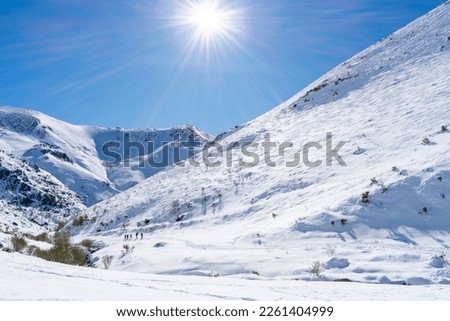 a mountaineers walking on snowy mountain on sunny day