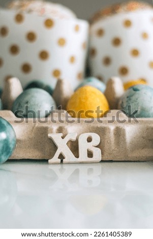 Easter cakes, eggs and the letters Christ is Risen on the table. Orthodox Christians. Vertical photo.