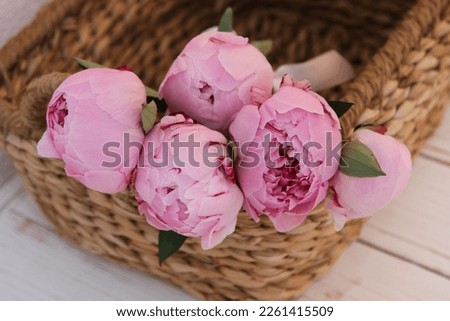 Beautiful pink peonies in the brown basket
