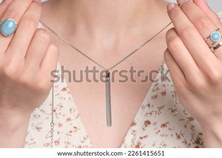 Woman Jewelery concept. Woman s hands close up wearing rings and necklace modern accessories elegant life style with copy space for text and background. Royalty-Free Stock Photo #2261415651