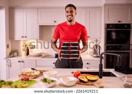 Portrait Of Man In Kitchen Wearing Fitness Clothing Making Batch Of Healthy Meals For Freezer Royalty-Free Stock Photo #2261419211