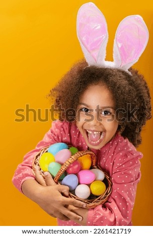 A Black girl with rabbit ears on her head with a basket full of colored eggs.