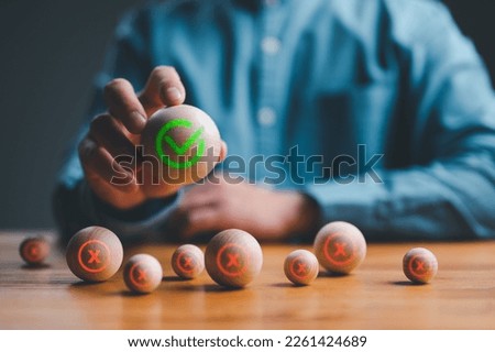 Businessman selected green correct sign mark from out Red Cross mark which print screen on wooden cercle for approve and reject business proposal concept.