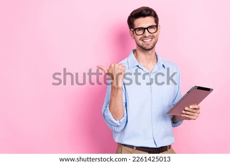 Photo of overjoyed man user modern gadgets arm direct empty space demonstrate sale device shop isolated on pink color background