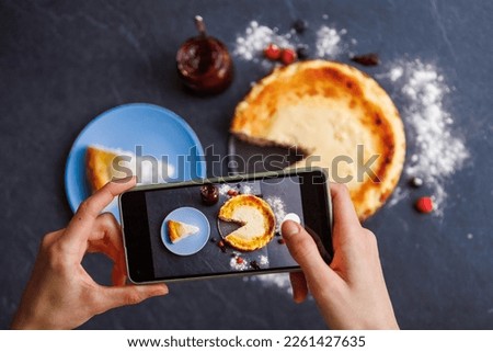 Woman hands taking a photo of a delicious cheesecake she is about to eat, screen view