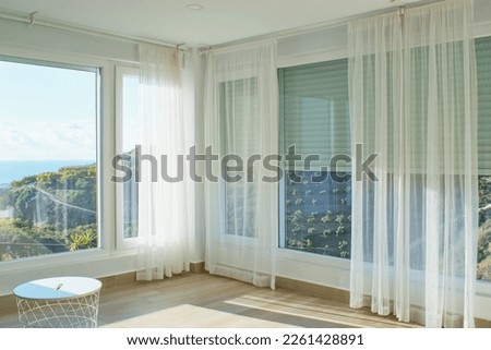 Cozy light home interior with large windows, blinds and courtains . Royalty-Free Stock Photo #2261428891