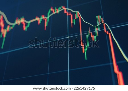 Diagram representing red crashing stock market volatility of crypto trading, where red candlesticks going down without resistance, market fear and downtrend on blue display background Royalty-Free Stock Photo #2261429175
