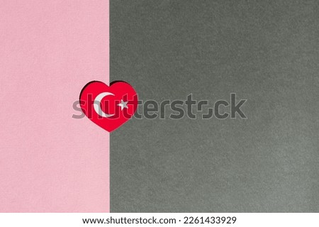 Turkey flag in the shape of a heart on a pink and gray background.