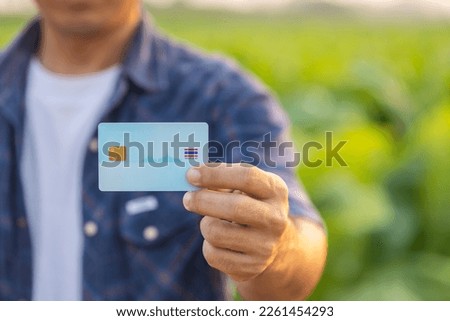 Close up farmer holding blank Thailand ID. Card while working in the tobacco field. Royalty-Free Stock Photo #2261454293