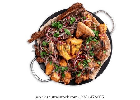 Assorted grilled meat with herbs and potatoes on a large plate. Pieces of a mix of fried meat from chicken, beef, pork and lamb, top view isolated on white Royalty-Free Stock Photo #2261476005