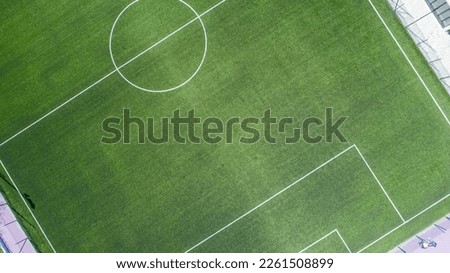 Aerial view of green football, soccer pitch. Top down view on a green, empty soccer field Royalty-Free Stock Photo #2261508899