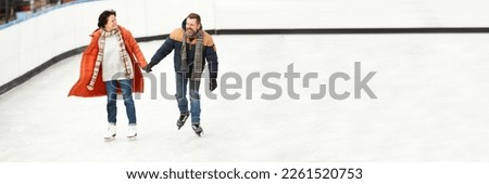 Middle-aged people, couple, man and woman in winter clothes skating on open air ice rink. Outdoor activity. Banner. Concept of leisure time, winter hobby, sport, vacation, fun, relationship, emotions.