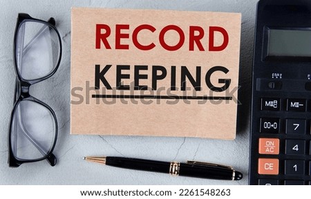 RECORD KEEPING - words on brown paper on the background of a calculator, glasses and a pen. Business concept