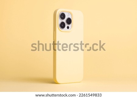 iPhone 13 and 14 Pro Max in yellow banana case back side view isolated on yellow background, monochrome colors phone case mock up