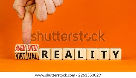 Augmented or virtual reality symbol. Concept words Augmented reality Virtual reality on cubes. Beautiful orange background. Businessman hand. Business augmented or virtual reality concept. Copy space.