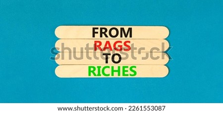 Rags or riches symbol. Concept words From rags to riches on wooden stick. Beautiful blue table blue background. Business rags or riches concept. Copy space.
