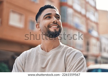 Young arab man smiling confident standing at street Royalty-Free Stock Photo #2261559567