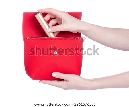 Female hand put make up brush into red bag cosmetic make up beauty on white background isolation