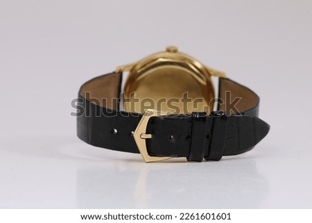 Showing the black leather strap and the gold buckle