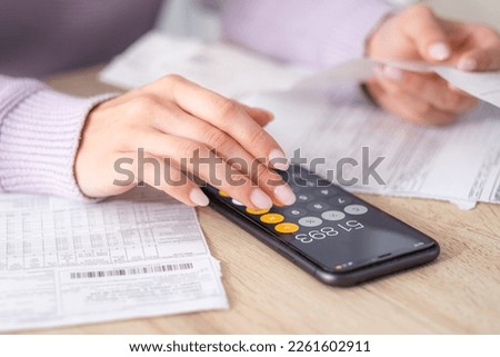 economical woman work on phone calculator at home pay bills taxes on gadget online, provident female calculate finances expenditures, manage plan family household budget on phone. Royalty-Free Stock Photo #2261602911