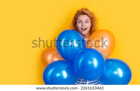happy girl hold party balloons in studio. shocked girl with balloon for party isolated on yellow