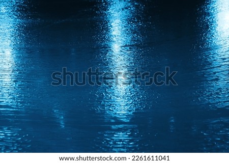 Blue ice rink texture with shiny lights reflections, abstract background photo