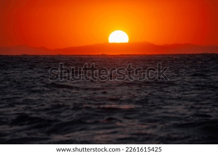 The sun sets over the Mediterranean Sea on the Greek island of Paros