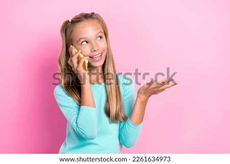 Photo of cute positive girl speak communicate telephone toothy smile isolated on pink color background