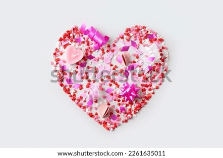 Celebration concept with pink confetti and event decoration in heart shape on white background, top view