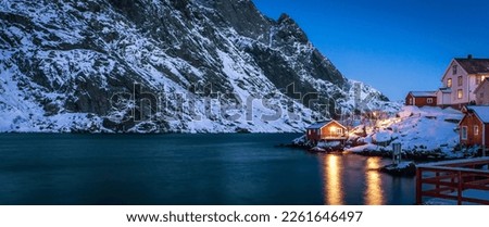 Amazing winter seascape. Nusfjord authentic fishing village with traditional red rorbu houses in winter during sunset. Lofoten islands, Norway. Typical north scenery of Lofoten islands. Norway Royalty-Free Stock Photo #2261646497
