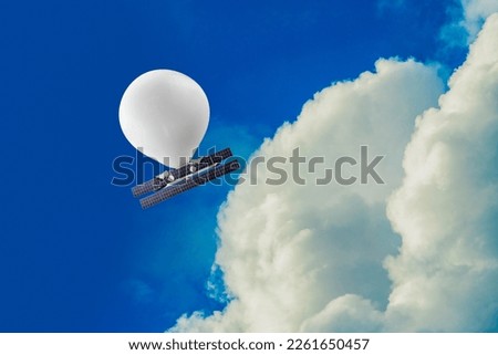 stratospheric balloon, complete with solar panels and cameras, travels at an altitude well above commercial air traffic in a blue sky Royalty-Free Stock Photo #2261650457