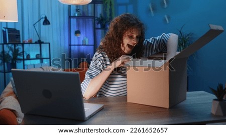 Happy surprised winner woman unpacking delivery parcel at home. Smiling satisfied girl shopper online shop customer opening cardboard box receiving purchase gift headphones by fast postal shipping Royalty-Free Stock Photo #2261652657