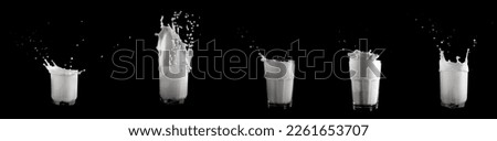 Glasses of milk with a splash on a black background