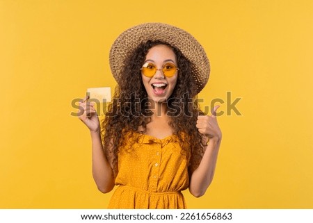 Successful pretty woman with unlimited gold credit card on yellow background. High quality photo