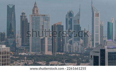 Rows of skyscrapers in financial district of Dubai aerial night to day transition timelapse. Panoramic view to many illuminated towers from Business bay district before sunrise