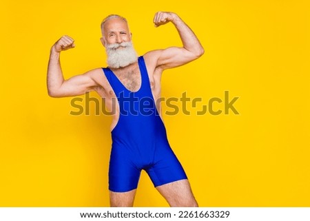 Photo of retired bodybuilder trainer sportswear costume demonstrate triceps empty space isolated on yellow color background