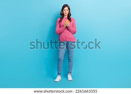Full body size cadre of concentrated woman influencer blogger hold smartphone wear casual stylish outfit chatting isolated on blue color background