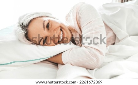 Young smiling pretty lady taking selfie picture lying on bed - Beautiful woman sleeping in bedroom - Life style and health care concept 