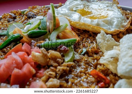 close up view of fried rice in a cafe, you can see some of the toppings that complement the menu such as eggs, chips and vegetables Royalty-Free Stock Photo #2261685227