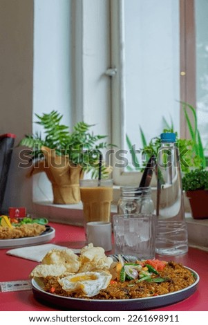 photo of a portion of fried rice along with cold water and coffee placed on the table and ready to eat