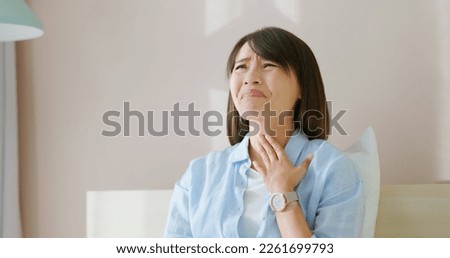 asian woman has allergy and she feel uncomfortable about her throat on bed in bedroom Royalty-Free Stock Photo #2261699793