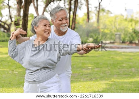 Asian senior couple practice yoga excercise, tai chi tranining, stretching and meditation together with relaxation for healthy in park outdoor after retirement. Happy elderly outdoor lifestyle concept Royalty-Free Stock Photo #2261716539